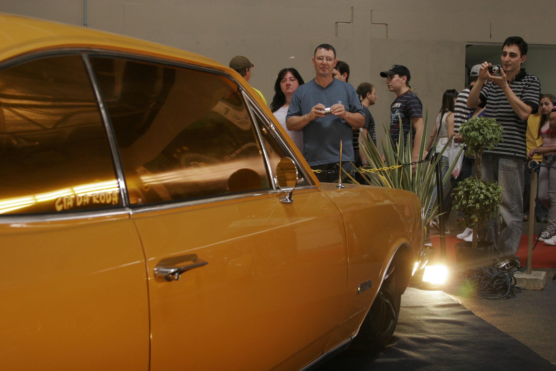 Varios carros expostos no Pavilhão Automotivo da EFAPI são fotografados pelos visitantes.