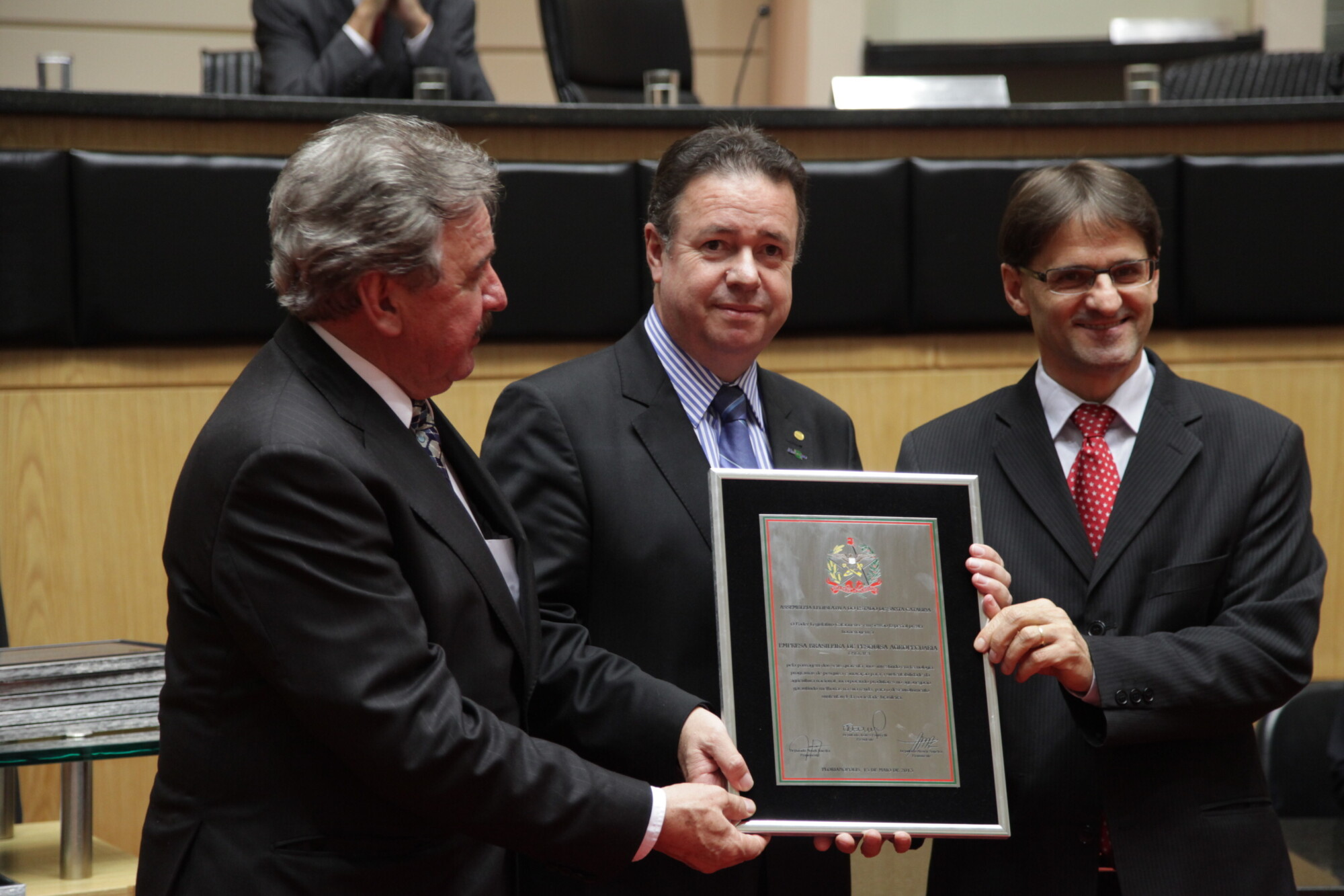 Ladislau Neto, da Embrapa, recebe homenagem dos deputados Moacir Sopelsa e Neodi Saretta. FOTO: Solon Soares/Agência AL