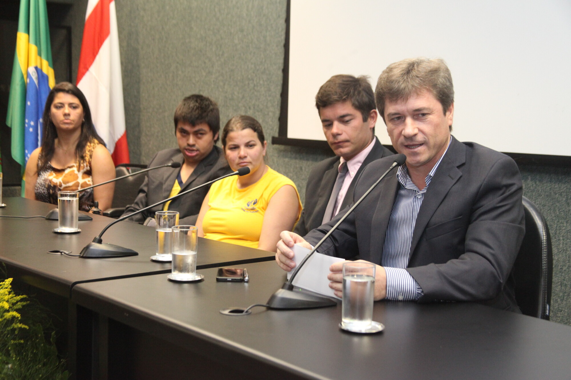 Deputado José Nei Ascari (ao microfone) participa da mesa de abertura do seminário