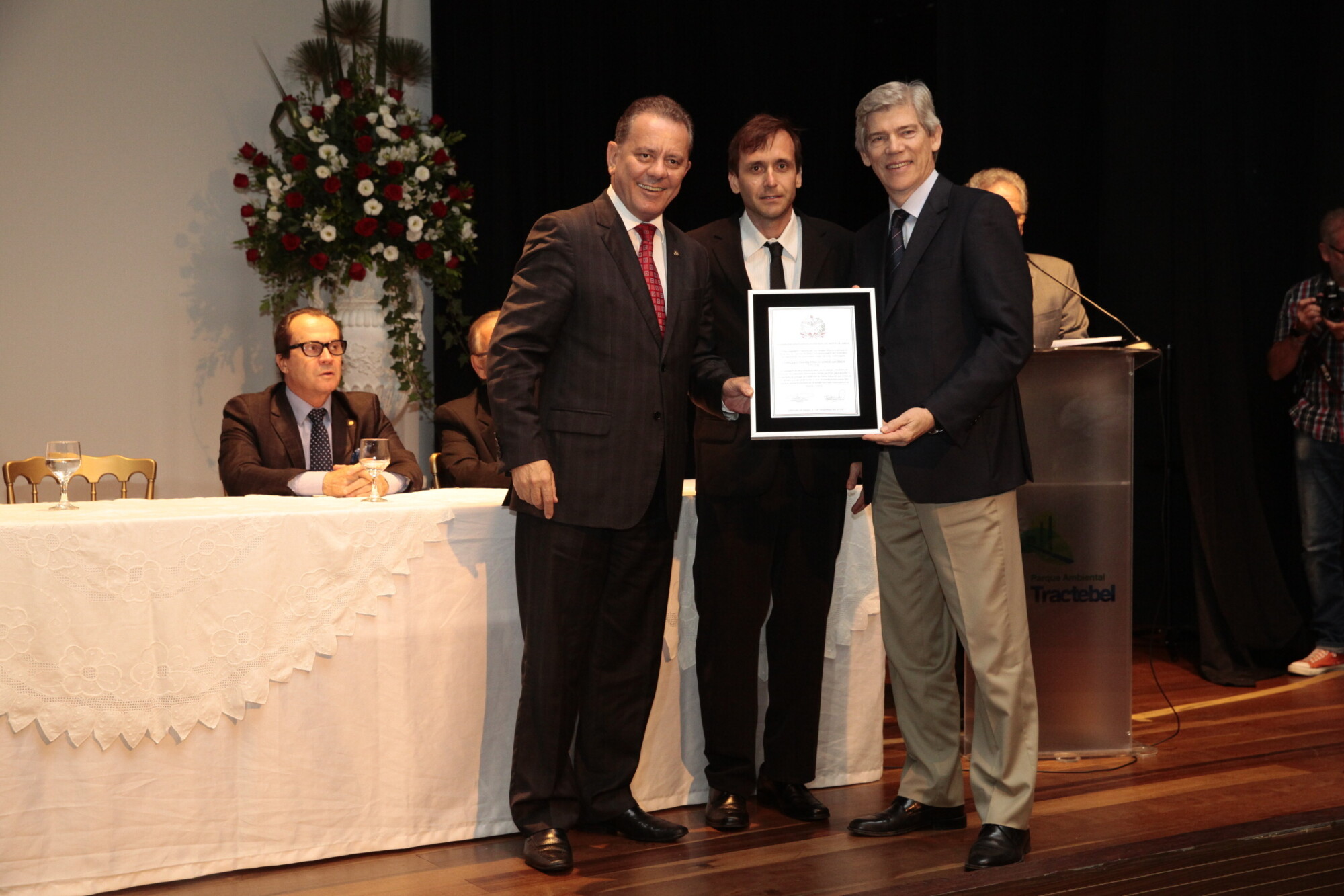 Ponticelli (e) e o diretor da Tractebel, José C. Minuzzo, entregam placa ao neto de Lacerda, Roberto Westrupp (centro). FOTO: Miriam Zomer/Agência AL