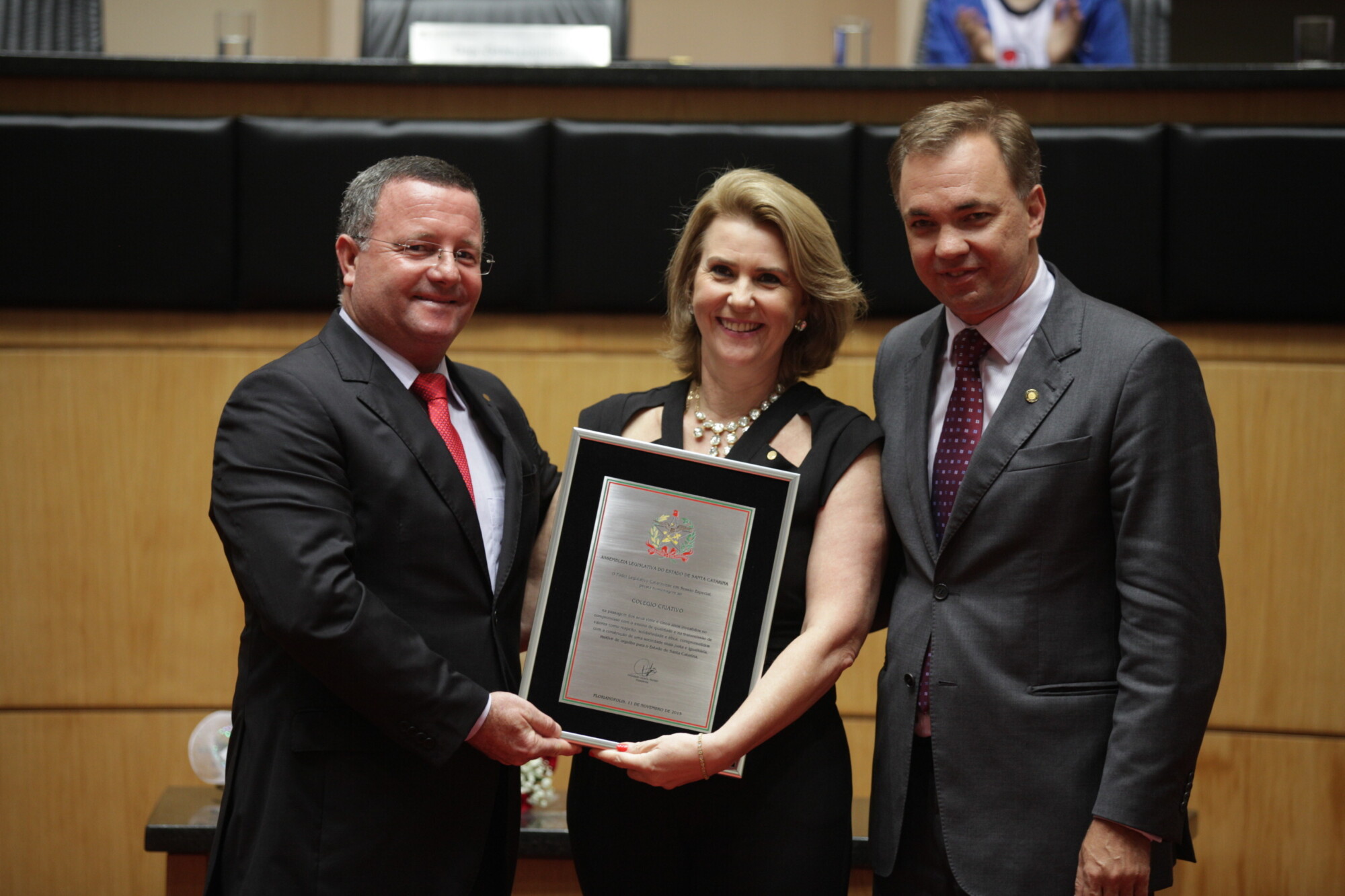 Luiz Gamba e Lélia Regina Kremer Gamba, diretores do colégio, recebem placa do deputado Gean Loureiro (d)