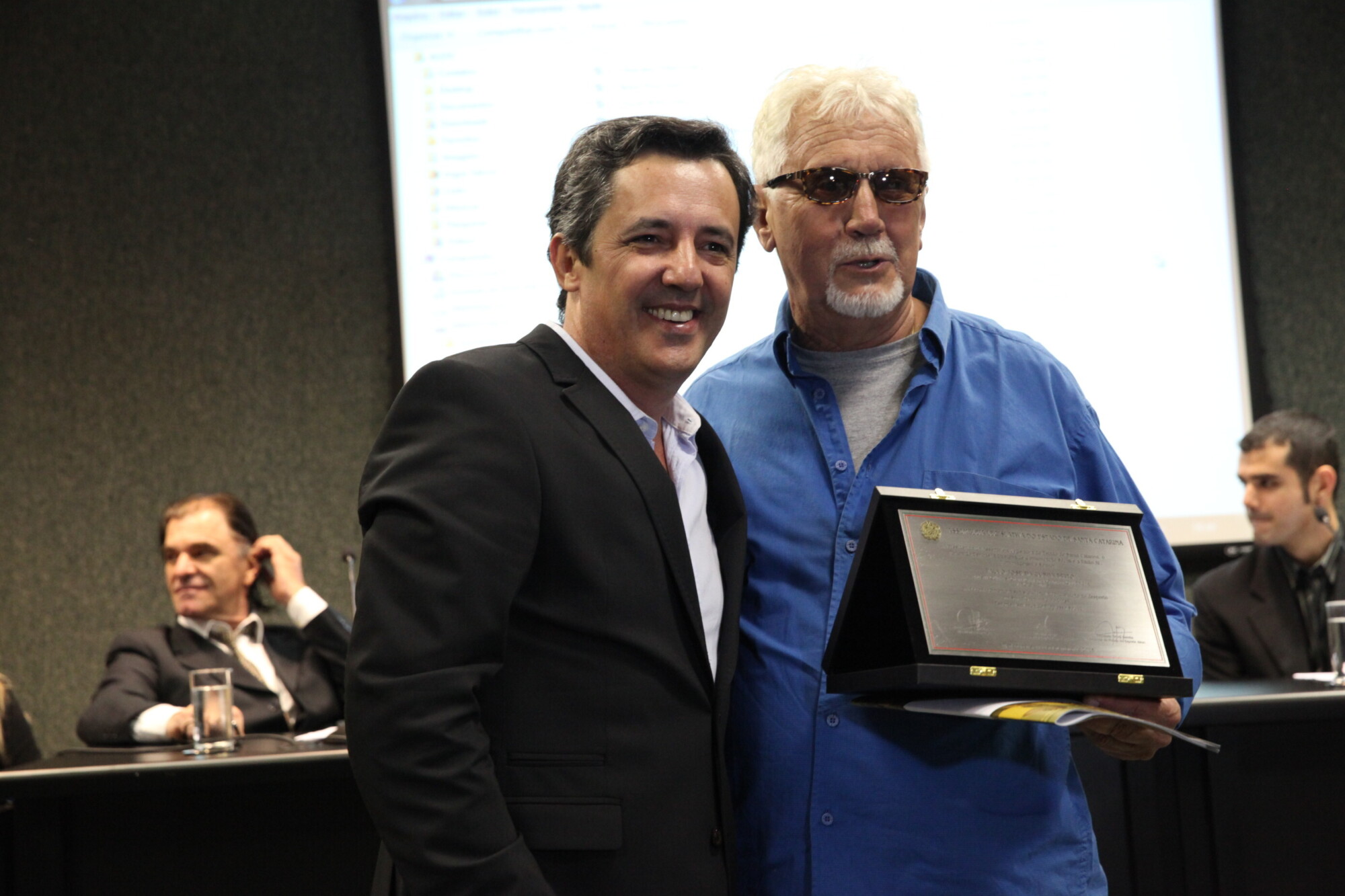 Carlos Eduardo Lino (E) entrega placa a Paulo Brito