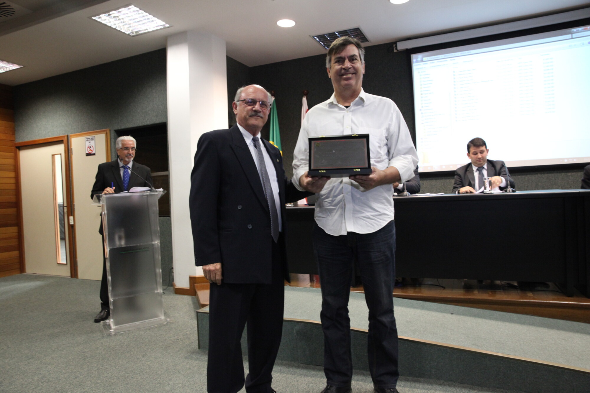 Oscar Archer (E) entrega placa a representante de Ana Destri