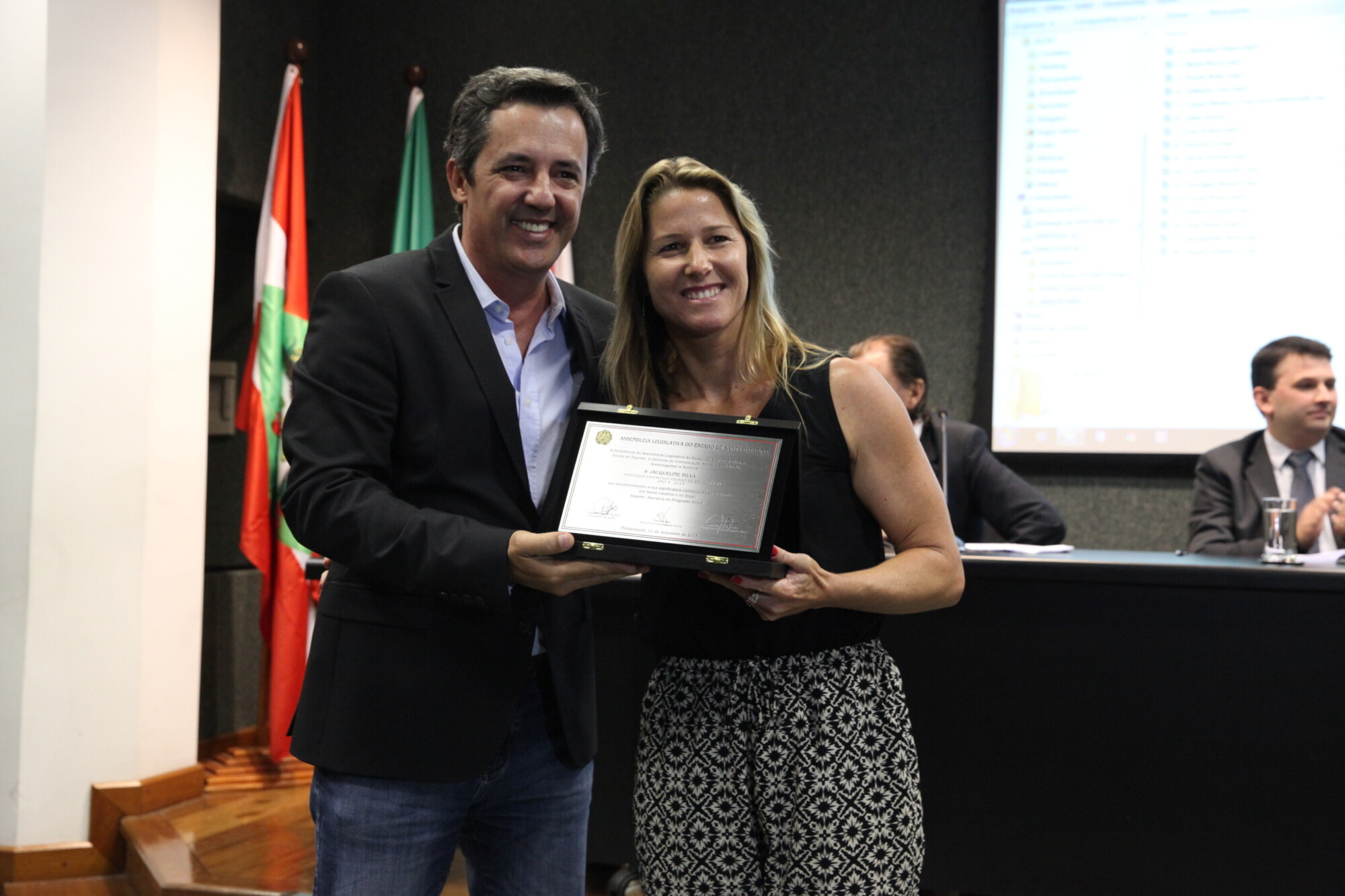 Carlos Eduardo Lino entrega placa a Jacqueline Silva