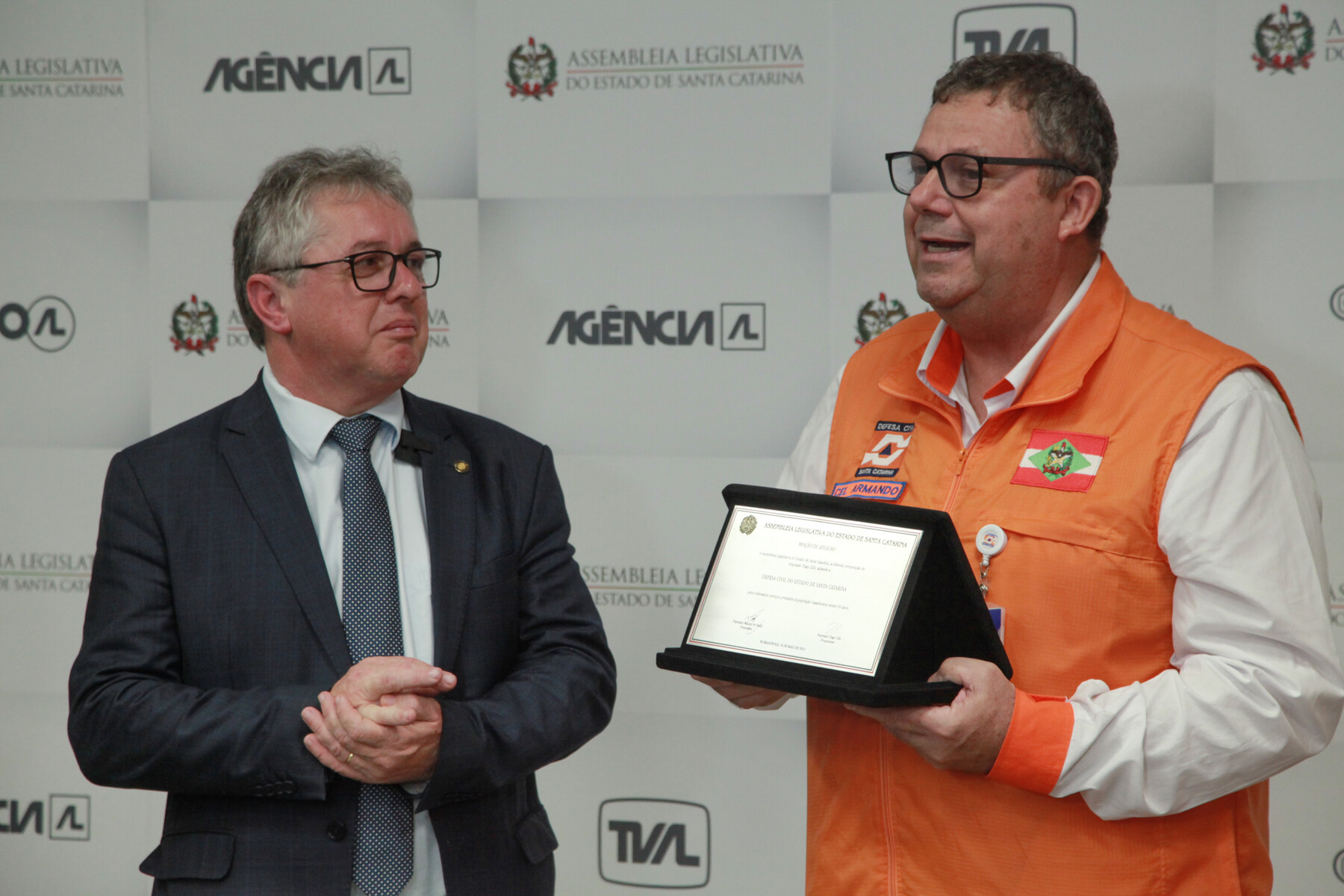 Secretário de Estado da Defesa Civil, Coronel Armando Schroeder Reis, recebendo a placa das mãos do deputado Tiago Zilli (MDB).