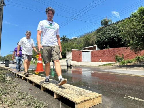 Marquito e artista plástico instalam passarela temporária para moradores desviarem de esgoto